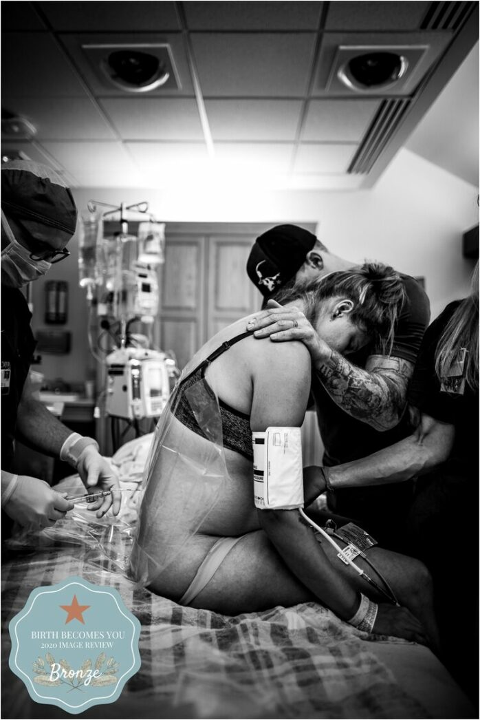 Vrouw leunt op haar partner tijdens de bevalling