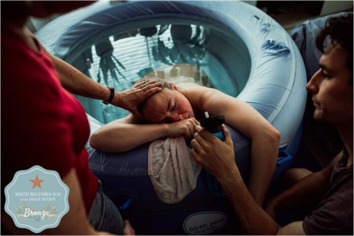 Vrouw houdt de hand van haar partners vast tijdens weeën