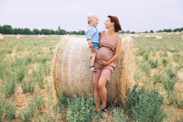 Vrouw is zwanger in de zomer en geniet van het mooie weer