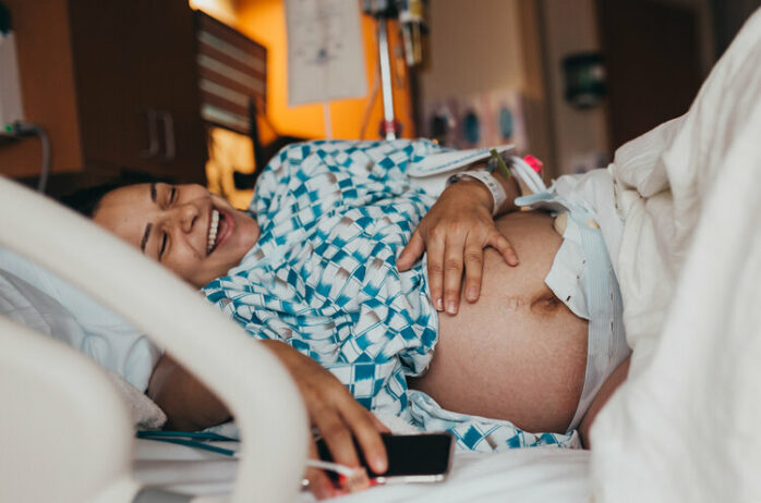 Vrouw die aan het bevallen is kan even lachen