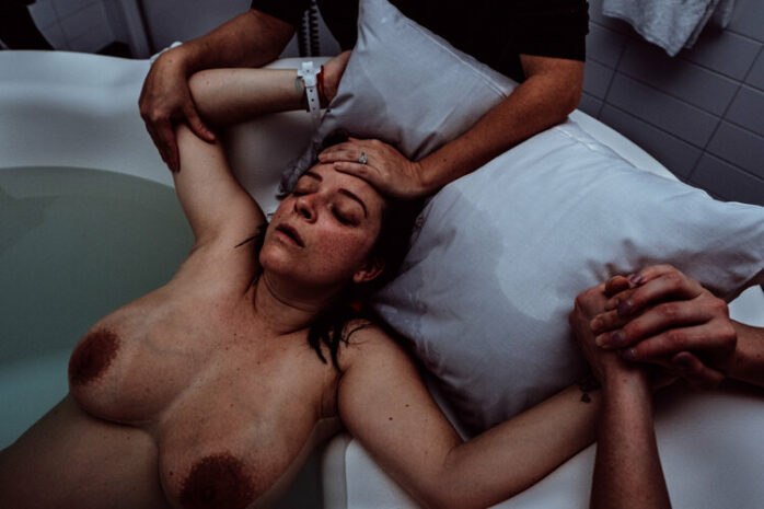 Vrouw vangt weeën op in bad