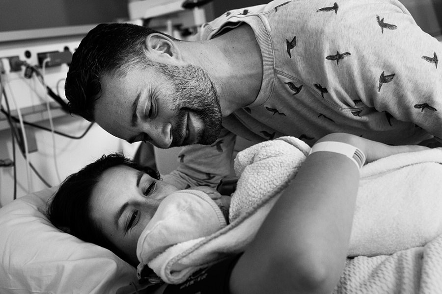 Vader en moeder met pasgeboren baby vlak na de bevalling