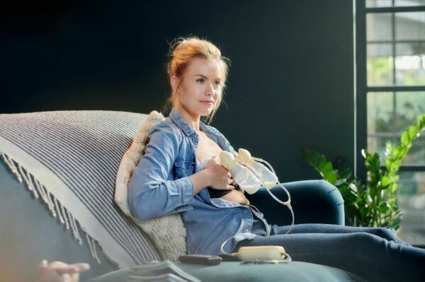 Vrouw kolft op de bank met Medela Freestyle Flex