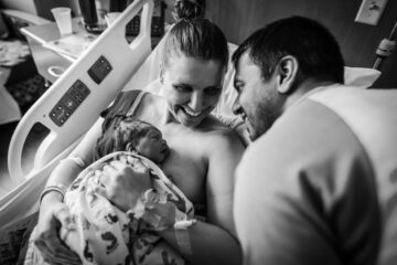 Kersverse ouders kijken gelukkig naar hun pasgeboren baby na het inleiden van de bevalling