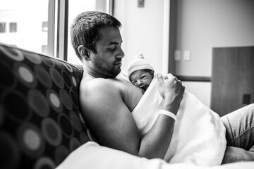 Vader en zijn pasgeboren baby hebben huid-op-huidcontact door te buidelen