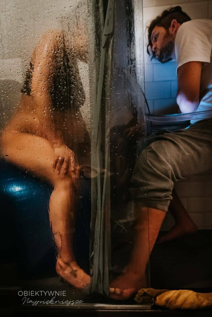 Man ondersteunt bevallende vrouw onder de douche