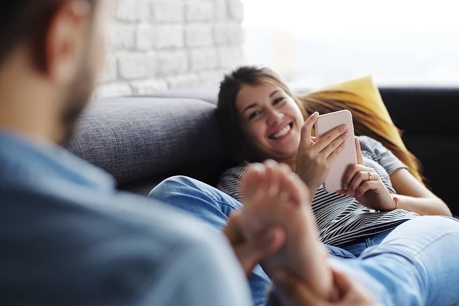 Man masseert de voeten van zijn zwangere vrouw die last heeft van stemmingswisselingen