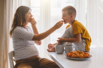 Vrouw eet gezonde snack tijdens de zwangerschap