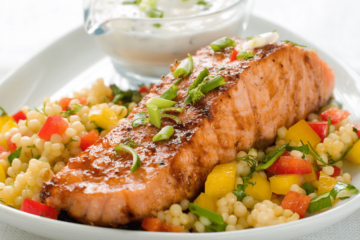 zalm met parelcouscous en groenten op een bord