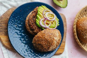 Gezonde bonenburgers met daarbovenop avocado en ui