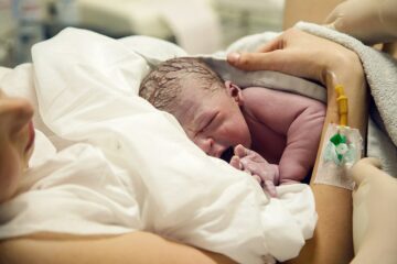 Neugeborenes kurz nach der Entbindung bei Mutter auf der Brust