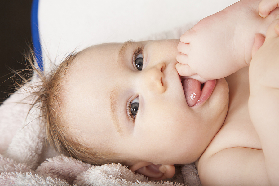 Baby 17 Wochen nimmt Fuß in den Mund
