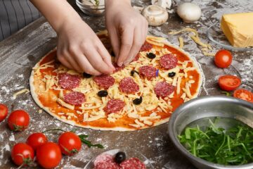 Salami in der Schwangerschaft Salamipizza wird von einer Frau belegt