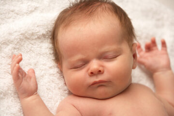 Babynamen 2022 Jungen - Babay schläft auf weißer Decke