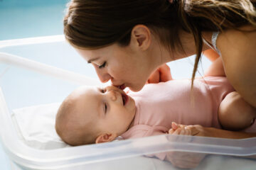 Oxytocin: Mutter küsst ihr Baby liebevoll auf die Wange