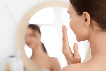 Melasma - Schwangerschaftsmaske - Frau betrachtet sich vor dem Spiegel