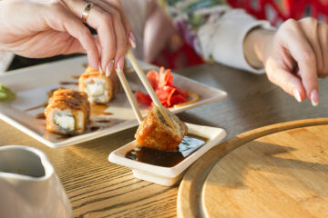 Sushi in der Schwangerschaft: Eine Frau tunkt ein Stück Sushi in die Sojasauce