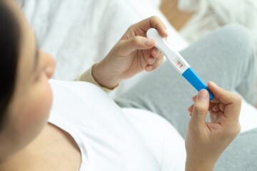 Hcg- Frau hält Schwangerschaftstest in der Hand