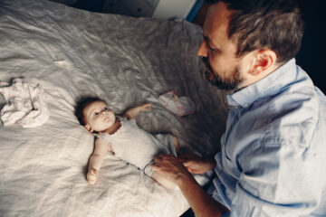 Verstopfung beim Baby. Papa wechselt seinem Baby die Windeln.