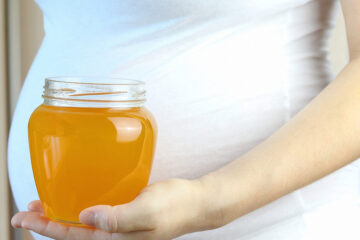 Schwangere mit einem Glas Honig in der Hand