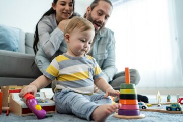 Baby spielt auf dem Boden mit einem Steckturn