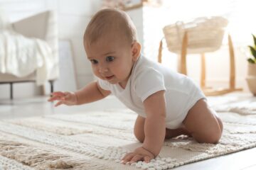 Baby macht erste krabbel versuche auf einem Teppich