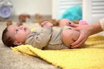 Eine Mama macht mit ihrem Baby Übungen für die Hüftdysplasie.