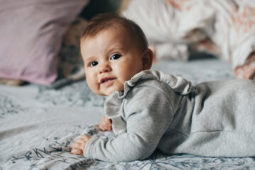 Mädchennamen 2023: Kleines Baby krabbelt auf dem Bett.