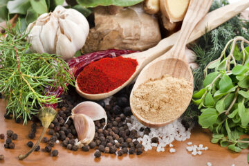 Kräuter und Gewürze liegen auf einem Tisch. Gewürze in der Schwangerschaft.