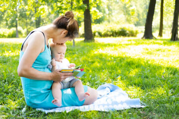 Mama liest ihrem Baby im Sommer ein Buch vor_12 Tipps bei Hitze