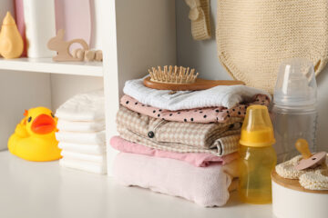 Ein Stapel Babykleidung liegt bereit für die Geburt.