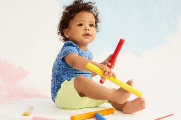 Baby spielt mit den Kreide, die es geschenkt bekommen hat.