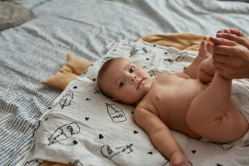 Ein aus einer Samenspende entstandenes Baby liegt auf dem Bett.