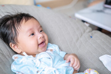 Baby mit Storchenbiss lacht.