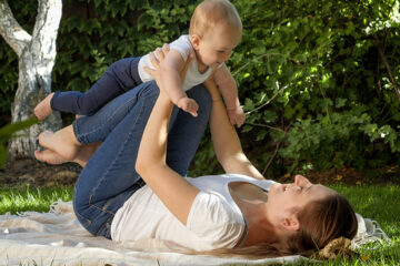 Grasmilben: Mama spielt im Gras mit ihrem Baby.
