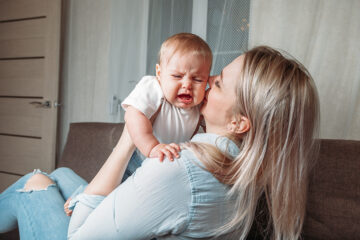 Baby schläft nicht ein und wird von Mutter auf den Arm genommen