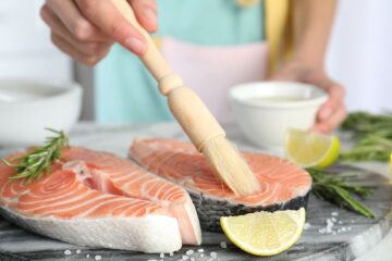 Omega-3-Fettsäuren: Schwangere bereitet Lachs zu.