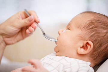 Baby bekommt Sab-Simplex-Tropfen mit einem Löffel.