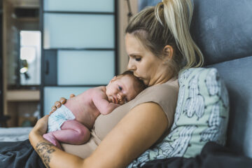 Wochenfluss: Mama kuschelt mit ihrem Baby.