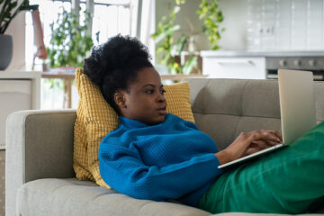 Frau sitzt auf dem Sofa und liest über Mönchspfeffer.