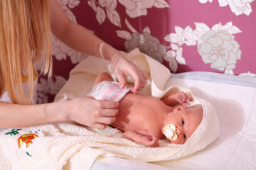 Mutter wickelt ihr Baby und wechselt die Windel