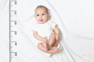 Wie groß wird dein Kind: Baby liegt auf dem Bett