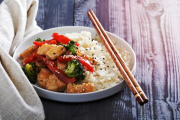 Leckere Hähnchen-Gemüsepfanne mit Reis und Stäbchen