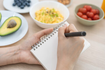 Frau schreibt einkaufsliste für leckere rezepte