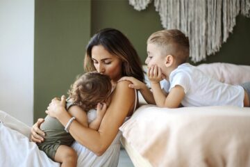 Mama-Blogger kuschelt mit ihren zwei Kindern.